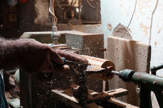 Плотник чистит древесину и придает ей форму