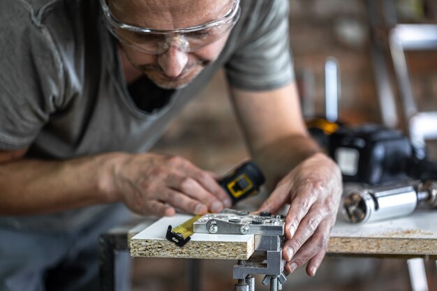 A carpenter in the process, a professional tool for precision drilling in wood.