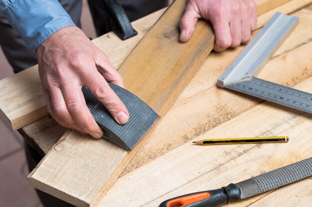 Carpenter in the process of renovating and making a wooden table