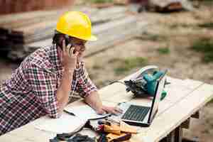 Free photo carpenter talking on mobile phone