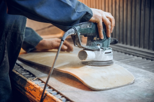 Foto gratuita falegname con sega circolare per il taglio di assi di legno. dettagli costruttivi del lavoratore maschio o uomo pratico con utensili elettrici