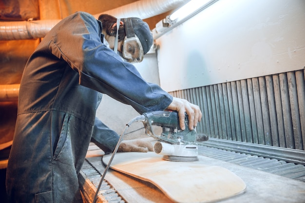 Carpenter using circular saw for cutting wooden boards. Construction details of male worker or handy man with power tools