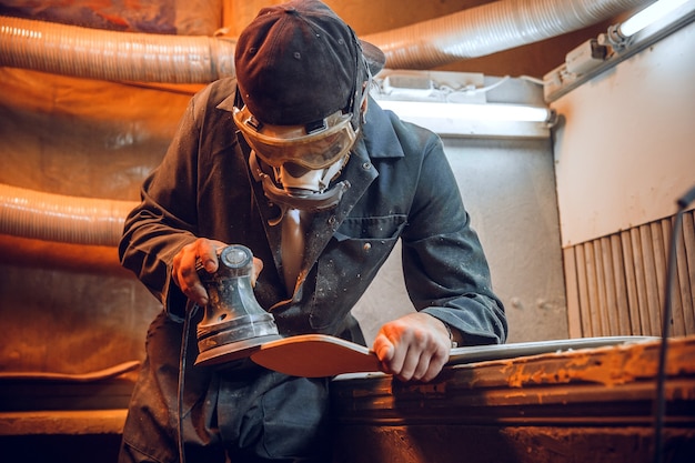 Carpenter using circular saw for cutting wooden boards. Construction details of male worker or handy man with power tools