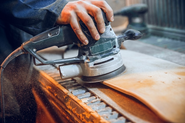 Carpenter using circular saw for cutting wooden boards. Construction details of male worker or handy man with power tools