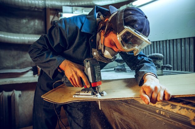 Carpenter using circular saw for cutting wooden boards