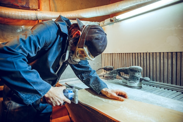 Carpenter using circular saw for cutting wooden boards