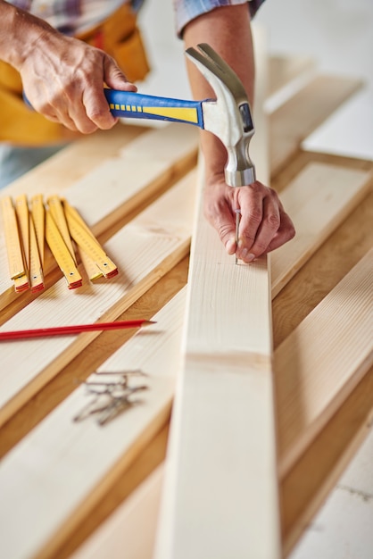 Carpenter with hammer hits wood