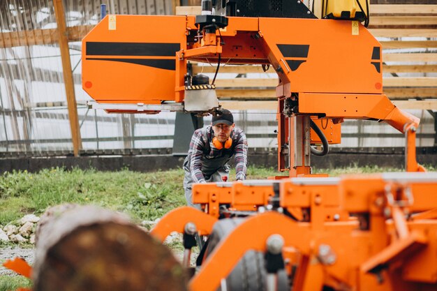 Carpenter working on a sawmill on a wood manufacture