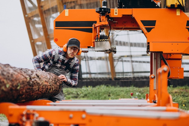 Carpenter working on a sawmill on a wood manufacture