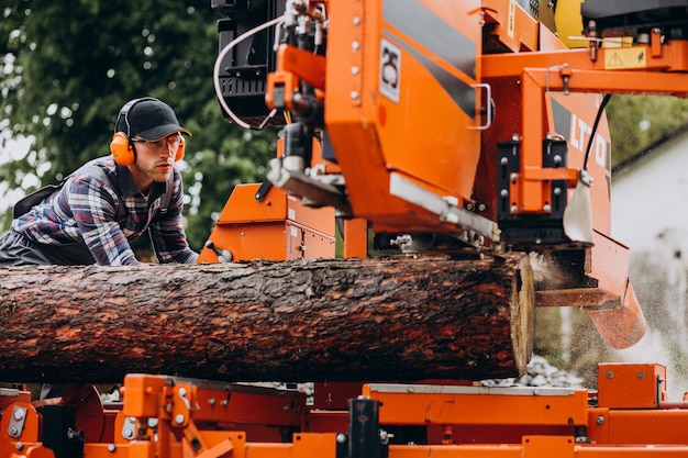 Carpenter working on a sawmill on a wood manufacture