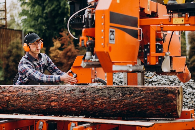 Carpentiere che lavora su una segheria su una fabbricazione di legno