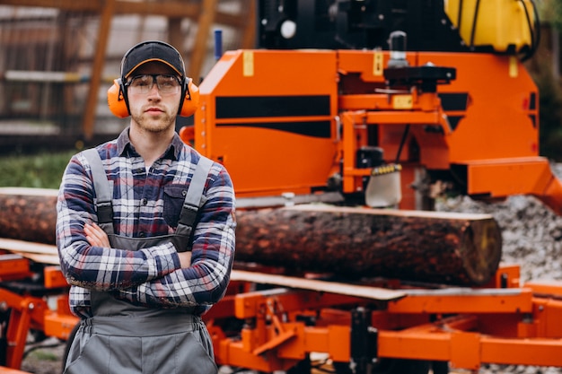 Carpenter working on a sawmill on a wood manufacture