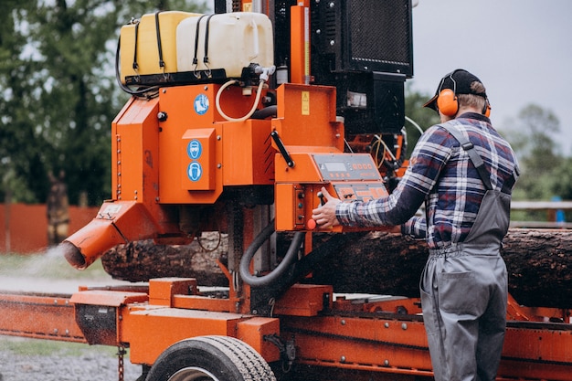 Free photo carpenter working on a sawmill on a wood manufacture