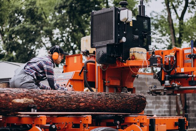 Carpenter working on a sawmill on a wood manufacture