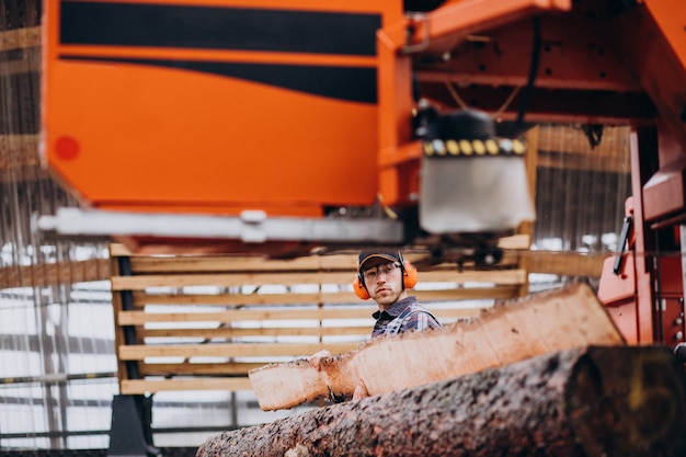 Carpenter working on a sawmill on a wood manufacture