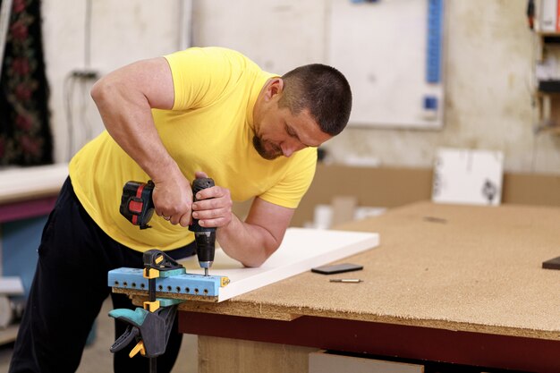 Carpenter working on wood craft at workshop to produce wooden furniture. Caucasian carpenter use professional tools for crafting. DIY maker and carpentry work concept.