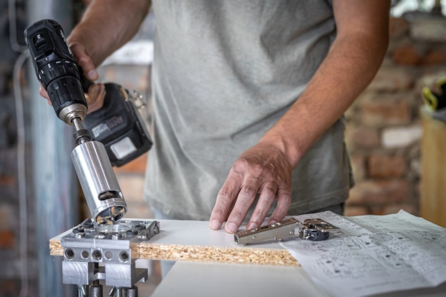 The carpenter works with a professional precision drilling tool.