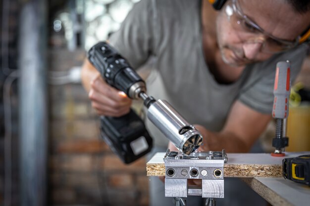 Плотник работает с профессиональным прецизионным сверлильным инструментом.