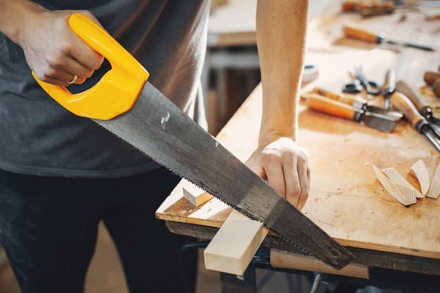 The carpenter works with a tree