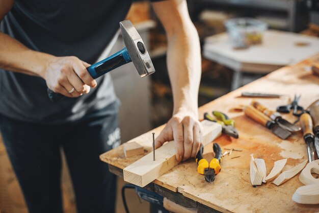 The carpenter works with a tree