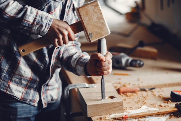 The carpenter works with a tree