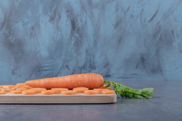 Free photo carrots on cutting board, on the marble background.