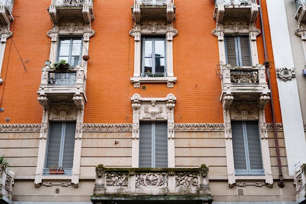 이탈리아 밀라노의 오래된 집 창문 위에 새겨진 돌 발코니와 처마 장식