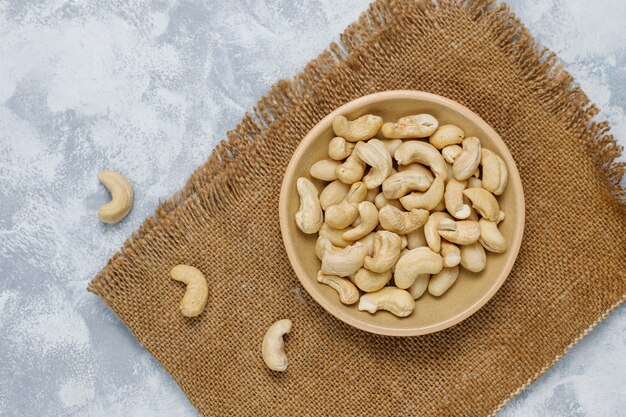 Cashew nuts in ceramic plate on concrete .top view