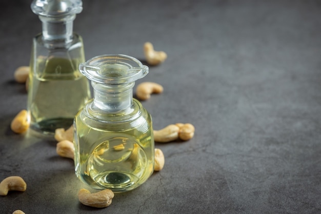Cashew nuts oil with cashew nuts on dark background