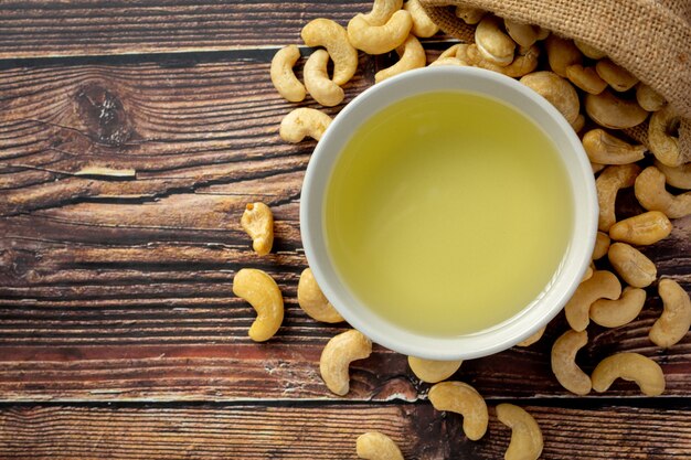 Cashew nuts oil with cashew nuts on dark wood background