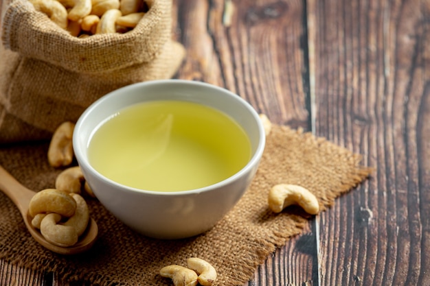 Cashew nuts oil with cashew nuts on dark wood background