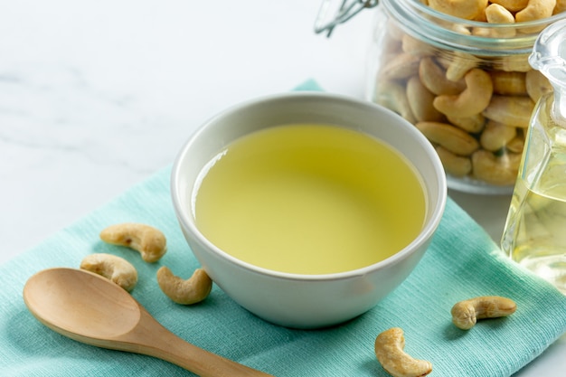 Cashew nuts oil with cashew nuts on marble background