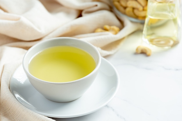 Cashew nuts oil with cashew nuts on marble background