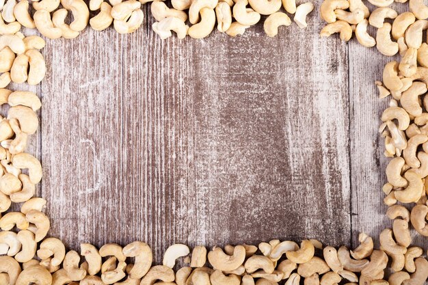 Cashew nuts on wooden background with copyspace available in studio photo. Raw healthy food