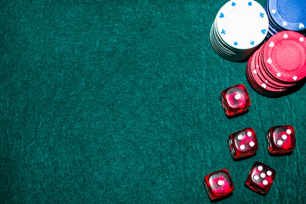 Casino chips and dice on green table