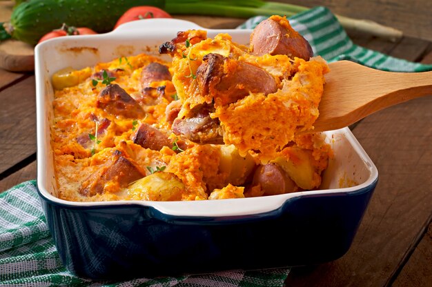 Casserole with sausage, bacon and apples in a pumpkin-cheese sauce