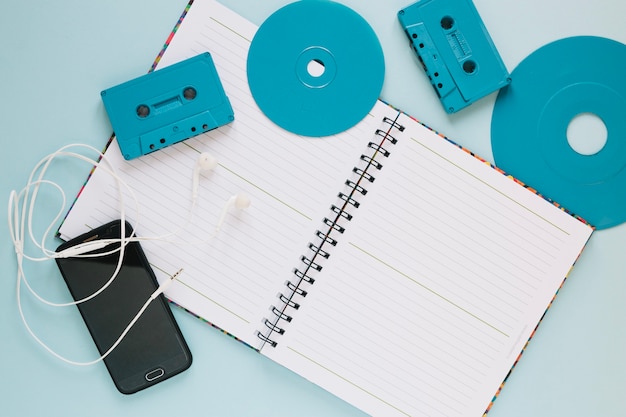 Cassettes and discs near notebook and smartphone