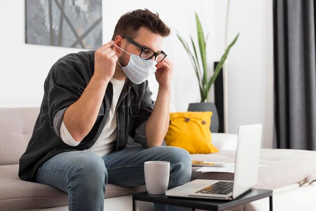 Casual adult male wearing face mask at home