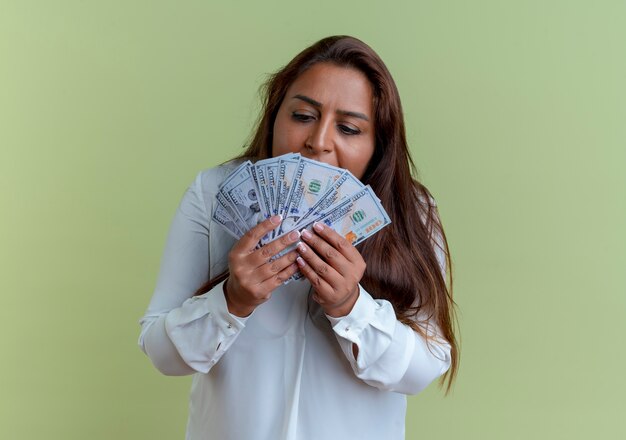 Повседневная кавказская женщина средних лет, держащая и смотрящая на деньги