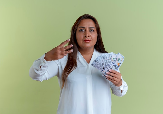 casual caucasian middle-aged woman holding money and showing three 