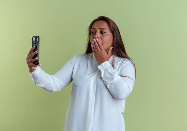 Casual caucasian middle-aged woman take a selfie and covered mouth with hand 