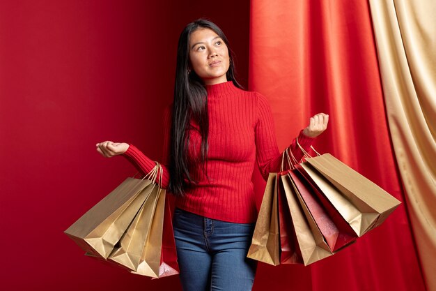 Casual dressed woman holding shopping bags for chinese new year