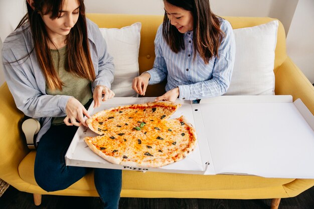 Casual friends eating delicious pizza