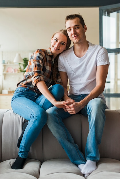 Free photo casual loving couple sitting together on sofa