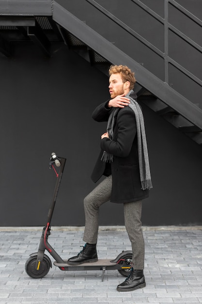 Casual male riding an electric scooter