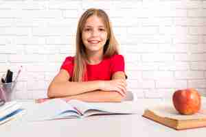 Free photo casual schoolgirl sitting at desk