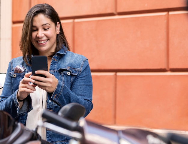 Foto gratuita adolescente casuale che passa in rassegna il suo telefono