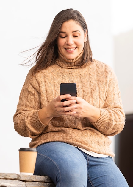 Foto gratuita adolescente casuale che passa in rassegna il suo telefono