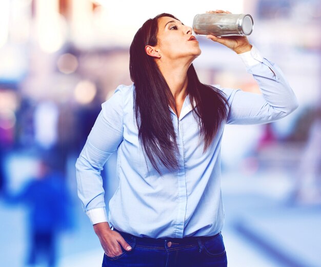 カジュアル女性は缶ビールを飲みます