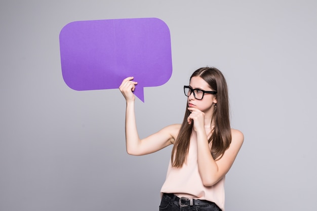 Free photo casual woman holding speech bubble isolated on white wall